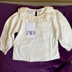 Creamy white blouse with ruffle detail. New with tags.